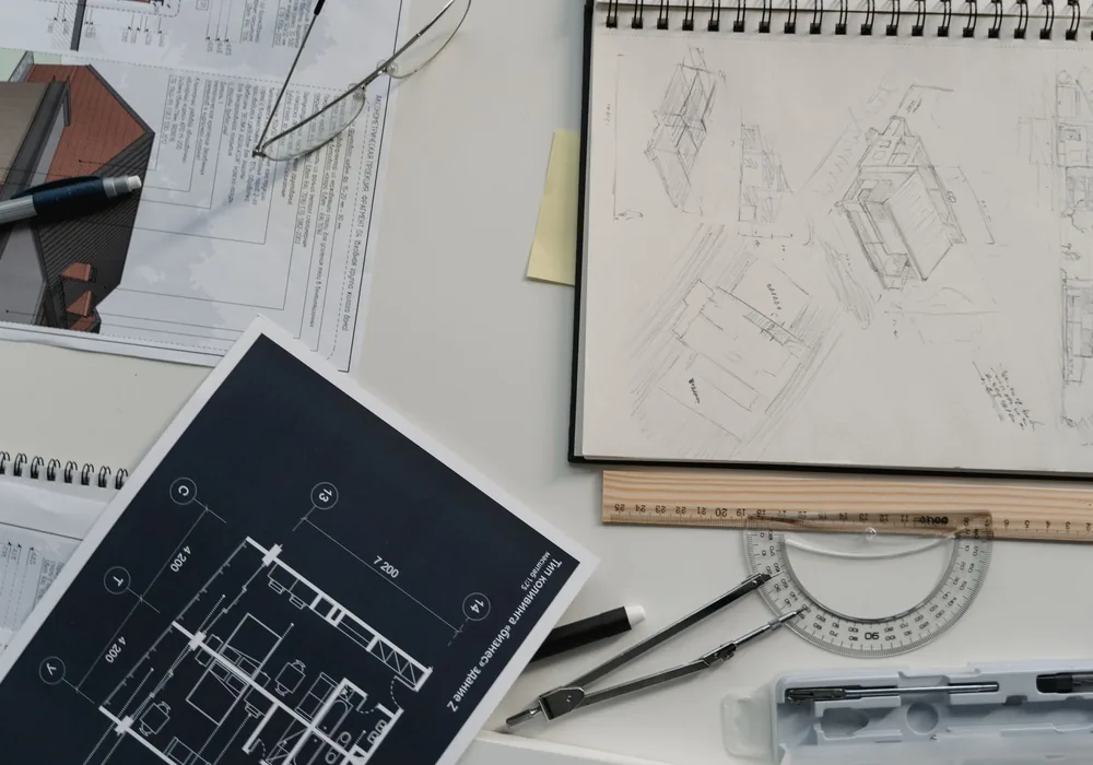 Architectural blueprint and sketches laid out on a drafting desk