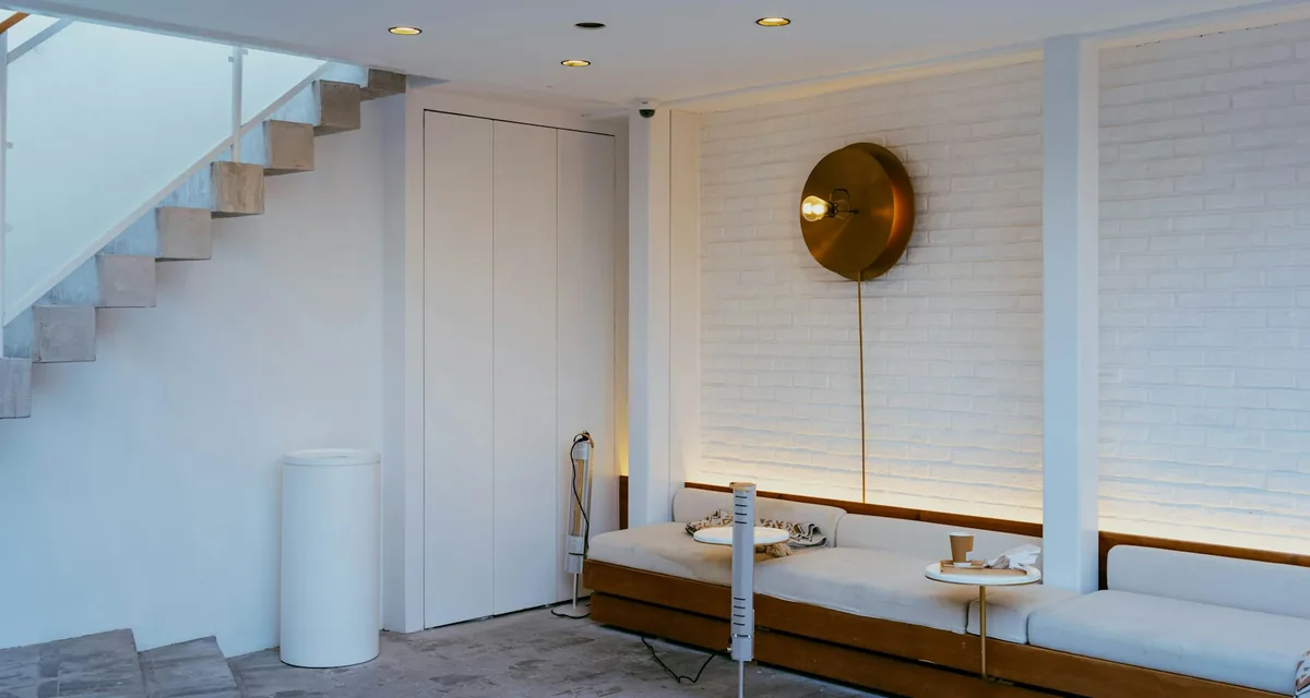 Minimalist white living space with concealed lighting and no visible equipment